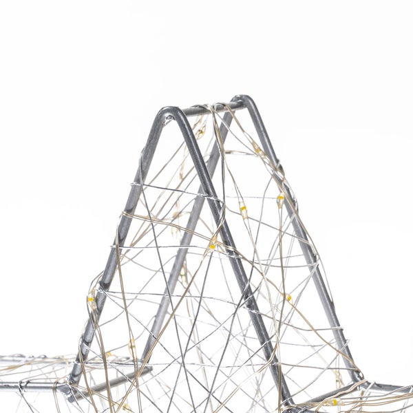 Detailansicht eines Sterns aus Metall mit einer Draht-Lichterkette und kleinen warmweißen LEDs.