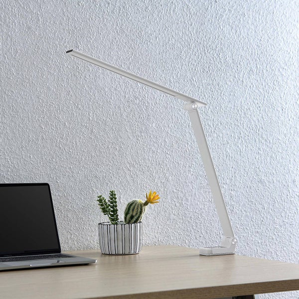 Moderne weiße LED Schreibtischleuchte mit verstellbarem Arm auf einem Holzschreibtisch neben einem Laptop und einem kleinen Kaktus.