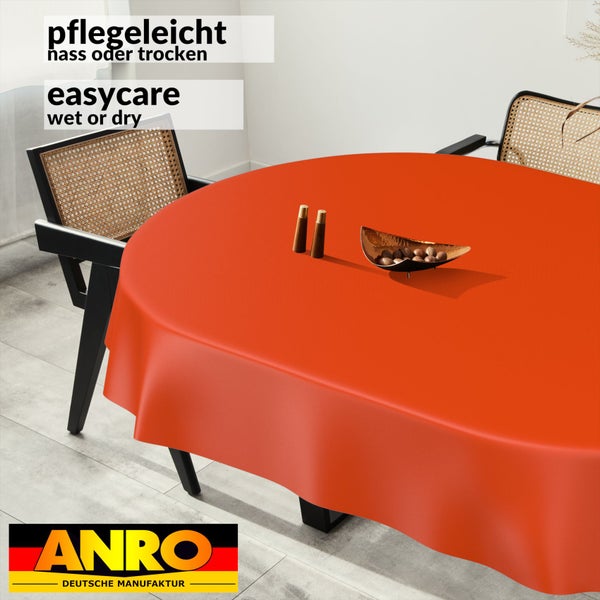 Runde pflegeleichte Tischdecke auf einem Tisch in einer hellen Umgebung mit Stühlen, ANRO DEUTSCHE MANUFAKTUR Logo.