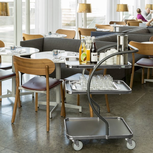 Restaurantinterieur mit Servierwagen, Getränken und Geschirr auf Tischen