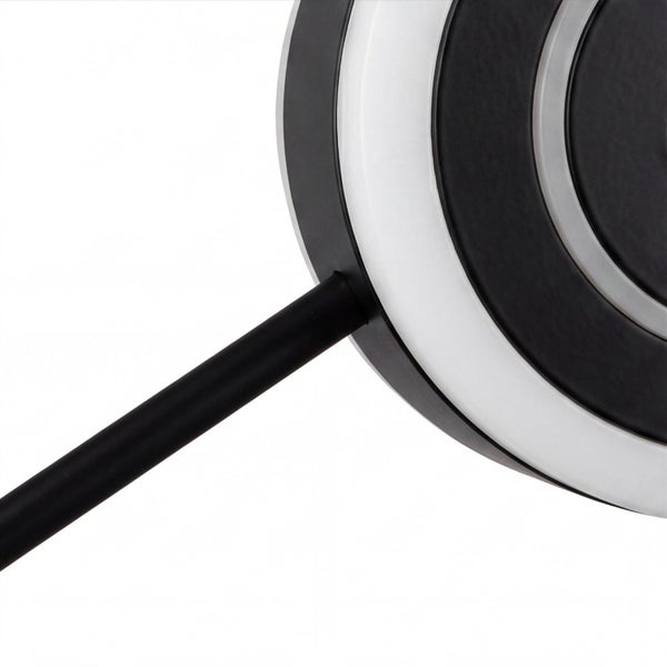 Detailansicht einer runden LED-Leuchte mit konzentrischen Ringen und einem schwarzen Metallstab.