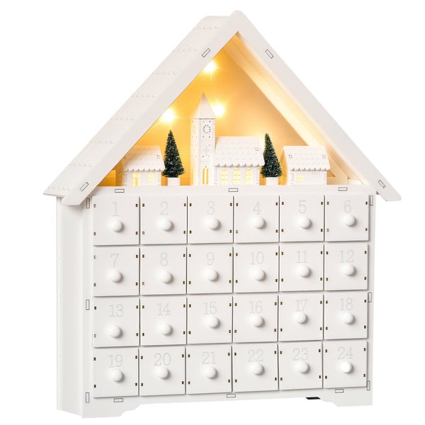 Weißer Adventskalender aus Holz in Hausform, 24 nummerierte Schubladen, beleuchtete Weihnachtsszene mit Kirche und Bäumen.
