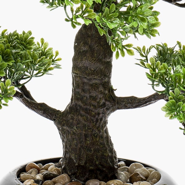 Künstlicher Bonsai mit braunem Stamm und grünen Blättern in einem Topf mit Zierkies.