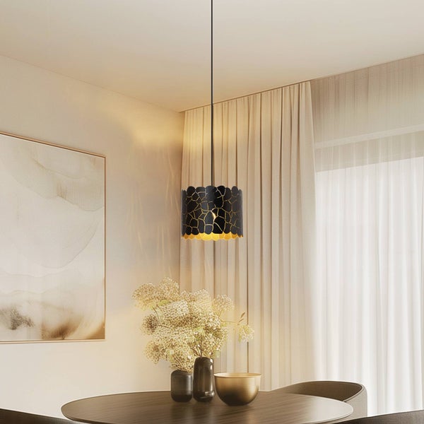 Moderne Pendelleuchte mit Lochmuster über einem Esstisch in einem hellen, aufgeräumten Raum mit Vorhängen und Wandbild.