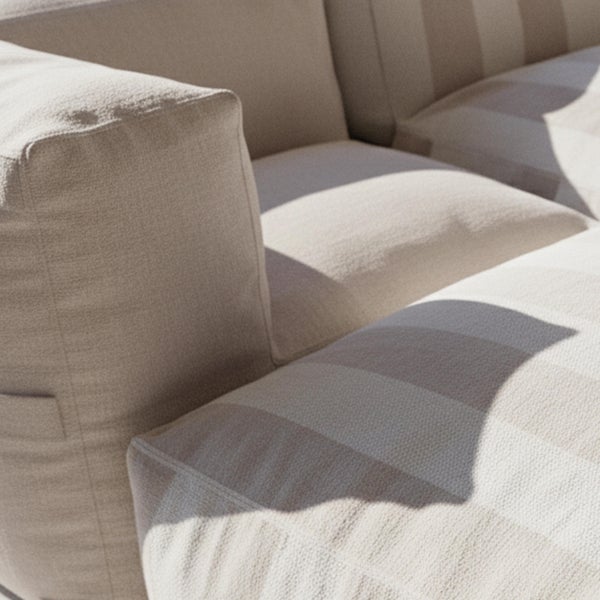 Schwarzer Bistro-Stuhl mit Lattenrückenlehne auf einem Holzboden vor einer Steinwand.