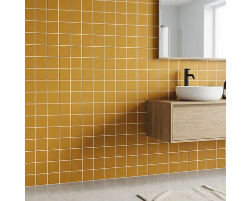 Modernes Badezimmer mit kleinen quadratischen Wandfliesen in Ocker, hängendem Holzunterschrank, weißem Aufsatzwaschbecken und schwarzer Armatur.