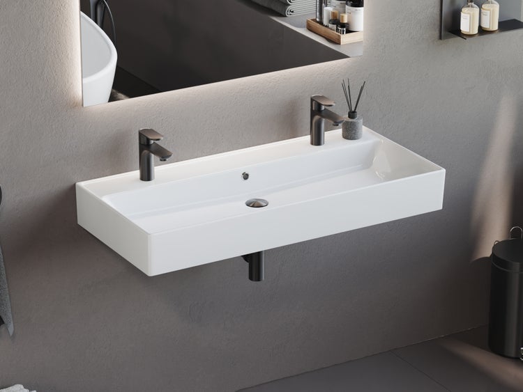 Rechteckiger Waschtisch aus Keramik mit zwei Armaturen im modernen Badezimmer.