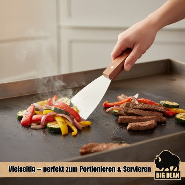 Gemüse und Fleisch werden auf einer Grillplatte mit einem Pfannenwender gewendet.
