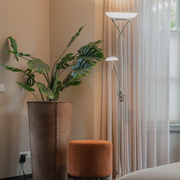 Innenaufnahme mit Zimmerpflanze im Pflanzgefäß, Hocker und Stehlampe