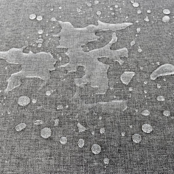 Nahaufnahme von Wassertropfen, die auf einem strukturierten, wasserabweisenden Stoff abperlen.