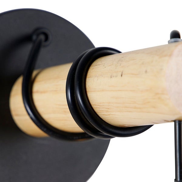 Detailaufnahme einer Wandgarderobe mit Holzstange und Metallhalterung