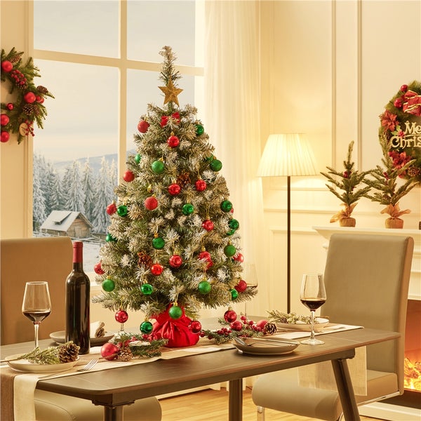 Festlich gedeckter Tisch mit Weihnachtsbaum und Dekoration für eine gemütliche Atmosphäre.