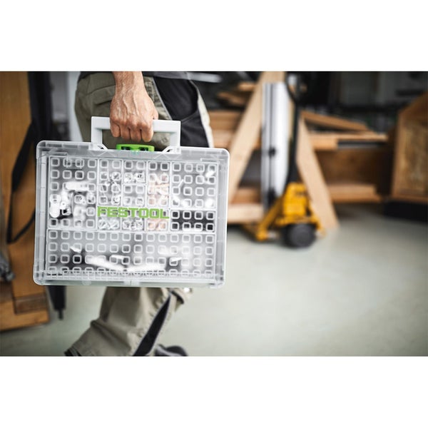 Hand trägt einen transparenten Festool Organizer Systainer mit Kleinteilen in einer Werkstatt.