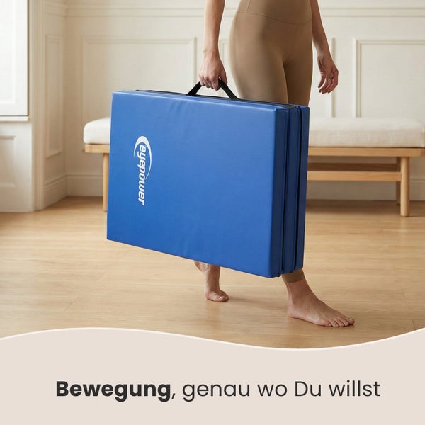 Eine Person trägt eine faltbare blaue Gymnastikmatte mit Tragegriff.