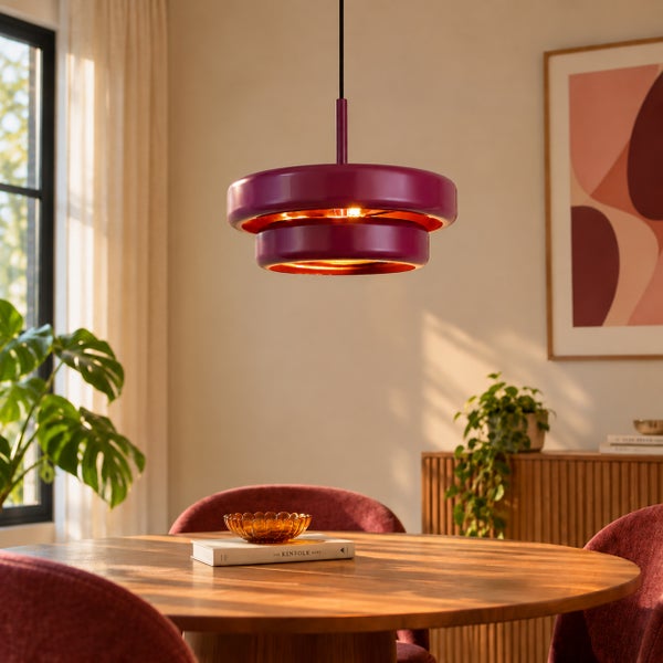 Moderne zweistufige Hängeleuchte über einem runden Holztisch in einem gemütlich eingerichteten Esszimmer.