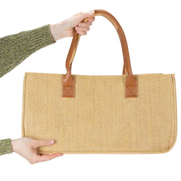 Geflochtene Tasche mit Griffen aus Kunstleder, von Händen gehalten.
