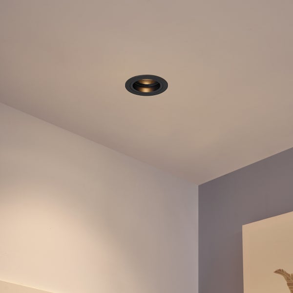 In die Decke montierter, runder Einbaustrahler in Schwarz.