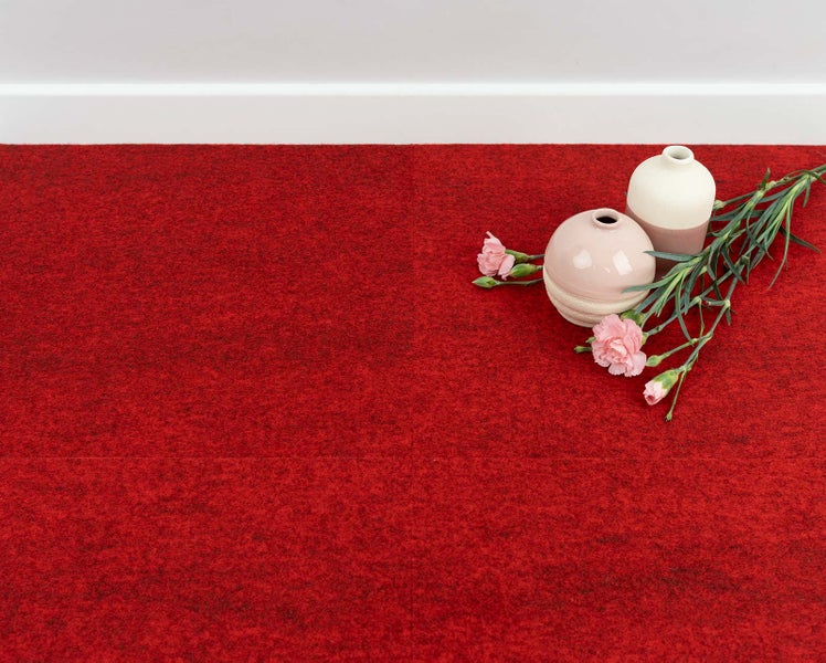 Rote Nadelfilz-Teppichfliesen als Bodenbelag in einem Raum mit dekorativen Vasen und Blumen.