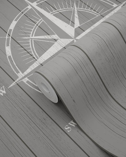 Tapetenrolle mit Kompassmotiv auf Holzstruktur