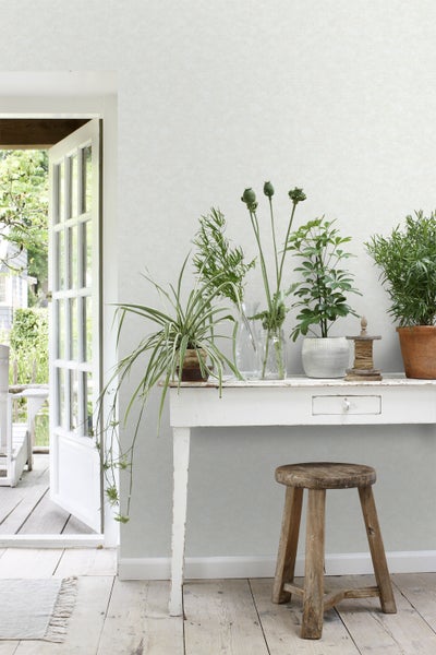 Helles Zimmer mit Tisch, Pflanzen und Holzstuhl