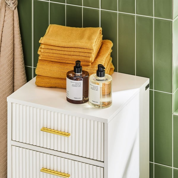 Badezimmer Szene mit weißem Badezimmerschrank, gelben Handtüchern und zwei Spendern für Duschgel