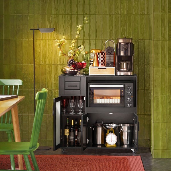 Küchenwagen mit Mikrowelle, Kaffeemaschine und Getränken vor grüner Wand