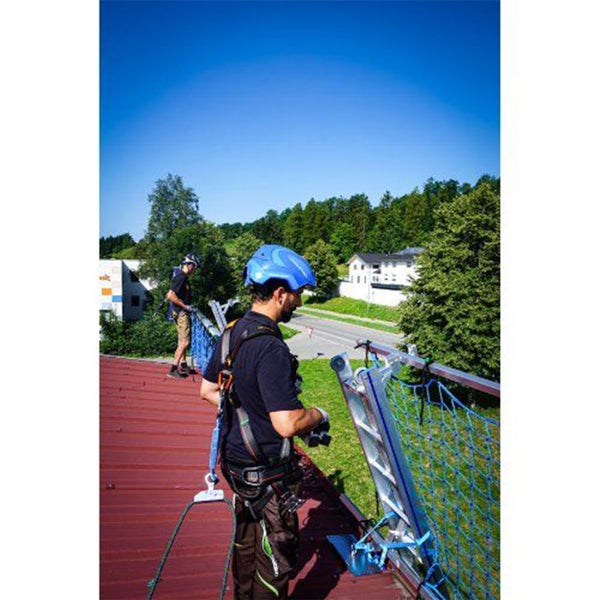 Zwei Dachdecker mit Sicherheitsausrüstung installieren eine Dachdecker-Schutzvorrichtung auf einem Dach.