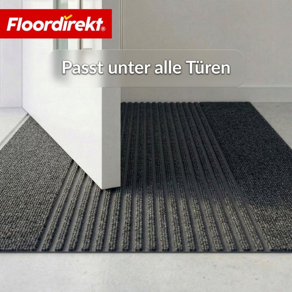 Floordirekt Logo. Gerippte Fußmatte unter einer offenen Tür, flaches Design passt unter alle Türen.