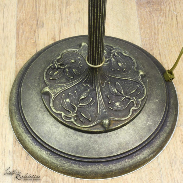 Detailaufnahme des Fußes einer Stehlampe mit floralem Muster.