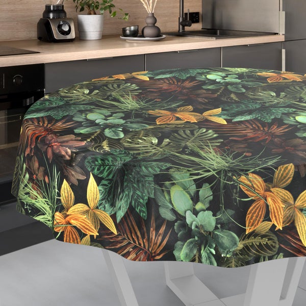 Runde Tischdecke mit tropischem Muster aus Blättern und Blüten auf einem Tisch in einer modernen Küche.