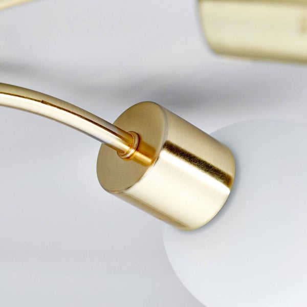 Detailaufnahme einer goldenen Deckenleuchte mit weißem Lampenschirm