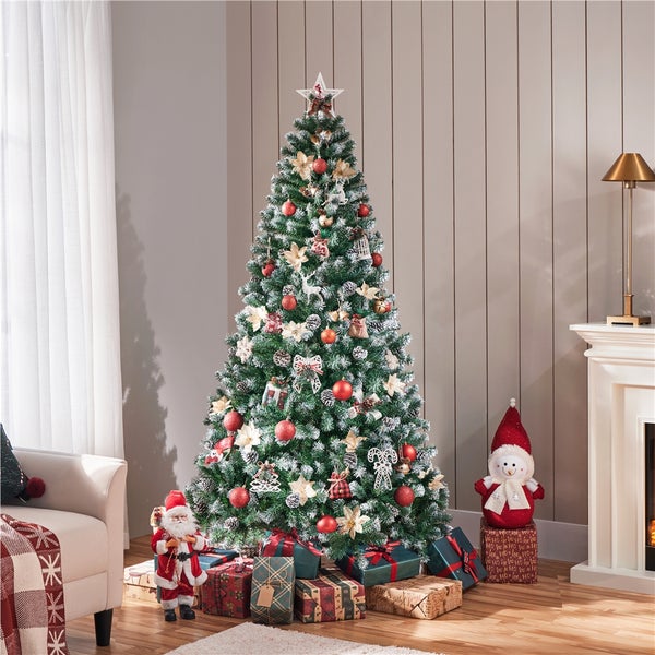 Geschmückter Weihnachtsbaum mit Geschenken und Dekorationen in einem Wohnzimmer.