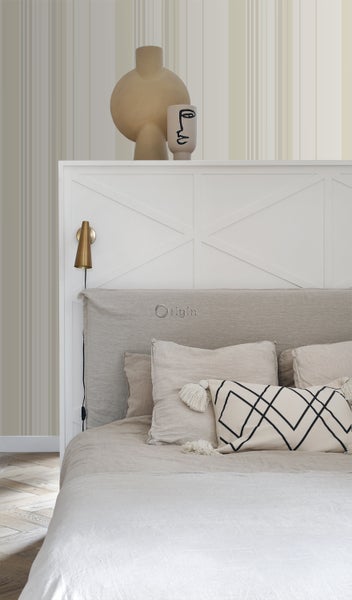 Schlafzimmer mit Bett, Kissen und dekorativen Objekten auf dem Kopfteil