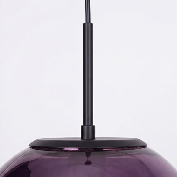 Detailansicht einer Pendelleuchte mit violettem Glasschirm und schwarzer Metallhalterung.