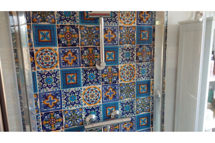 Dusche mit Mosaikfliesenmuster und Duscharmatur