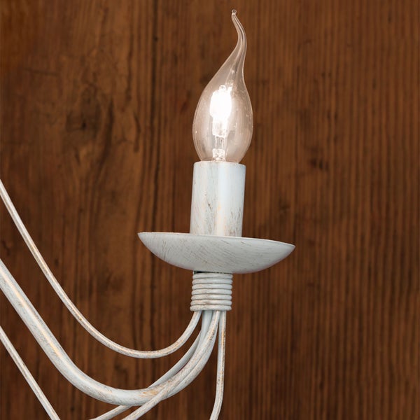 Detailansicht einer Kronleuchterfassung im Landhausstil mit Kerzenlampe in Tropfenform und gewischter Metalloberfläche.
