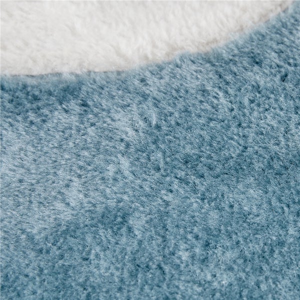 Detailansicht eines Teppichs mit blauem Flor und weißem Rand