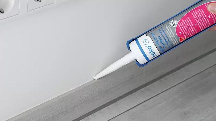 Anwendung von beko Maler-Acryl Turbo mit einer Kartuschenpistole an einer Fuge zwischen Wand und Arbeitsplatte.