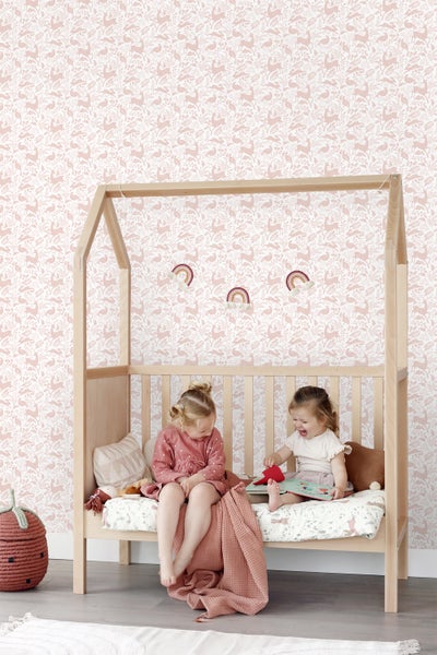 Kinderzimmer mit Holzbett, dekorativer Tapete, zwei Kindern und verspielten Accessoires