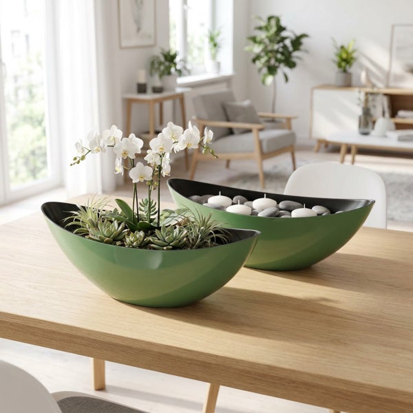 Zwei bootfoermige Dekoschalen auf einem Holztisch, eine bepflanzt mit Orchideen und Sukkulenten, die andere mit Steinen und Kerzen dekoriert.