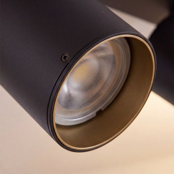 Detailansicht eines zylindrischen LED-Strahlers aus Metall mit schwarzem Gehäuse und goldfarbenem Innenring.