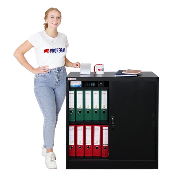 Büroszene mit einem schwarzen Aktenschrank mit Schiebetüren, der Ordner enthält und von einer Frau präsentiert wird.