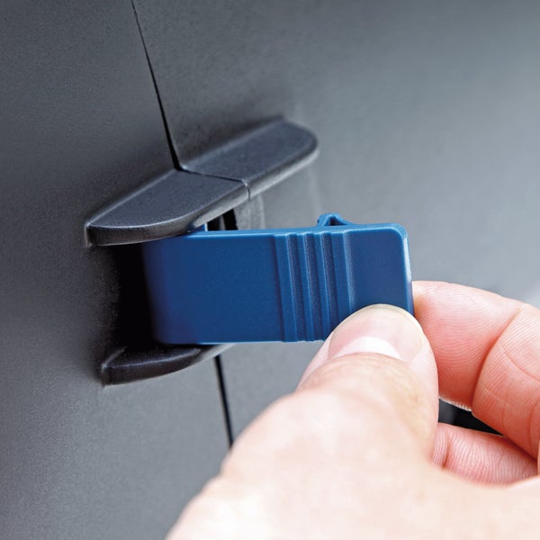 Nahaufnahme einer Hand, die eine blaue Kunststofflasche an einem schwarzen Gehäuse betätigt.