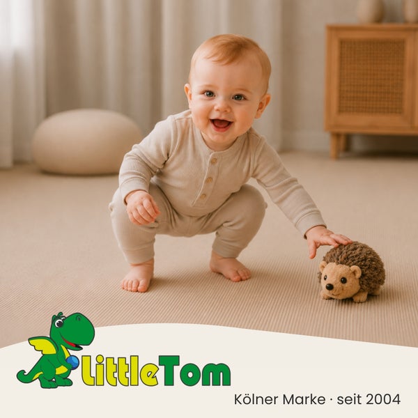 Ein lächelndes Baby hockt auf einem Teppichboden und spielt mit einem Plüschigel, dazu Little Tom Logo.