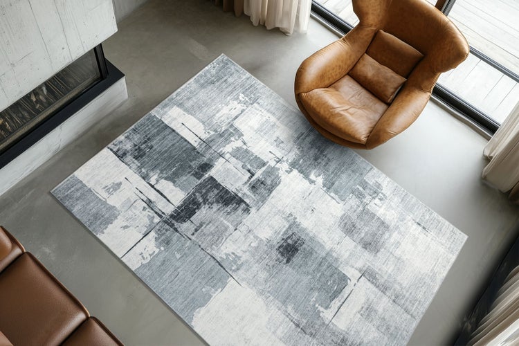 Moderner Wohnteppich mit abstraktem Muster in einem modern eingerichteten Wohnzimmer mit Kamin und Ledersesseln.