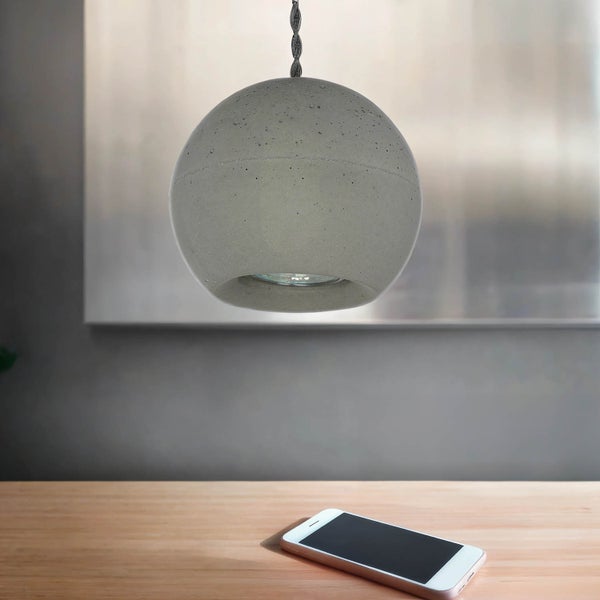 Kugelförmige Beton Pendelleuchte über einem Tisch mit einem Smartphone