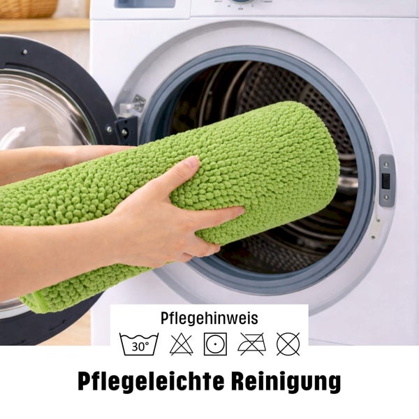 Ein gerollter Badteppich wird in eine Waschmaschine gelegt. Symbole weisen auf die einfache Reinigung bei 30 Grad hin.