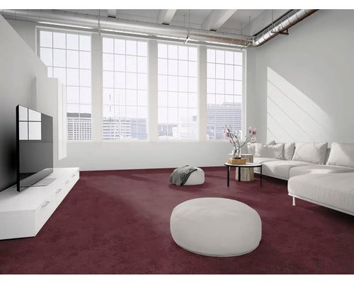 Moderner, heller Wohnraum mit großflächigem lila Teppichboden, weißem Sofa und großen Fenstern im Industriestil.