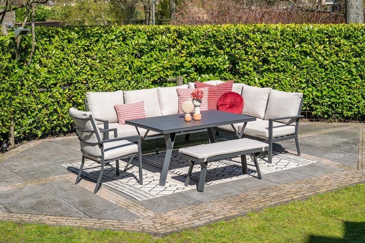 Modernes Garten-Lounge-Set mit Ecksofa, Sessel, Bank und rechteckigem Tisch. Dunkles Metallgestell mit hellgrauen Polstern auf einer Terrasse.