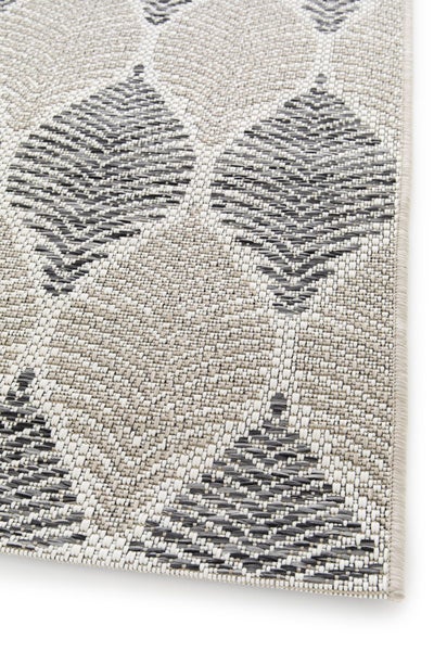 Flachgewebe-Teppich mit grafischem Blattmuster und festem, geketteltem Rand.